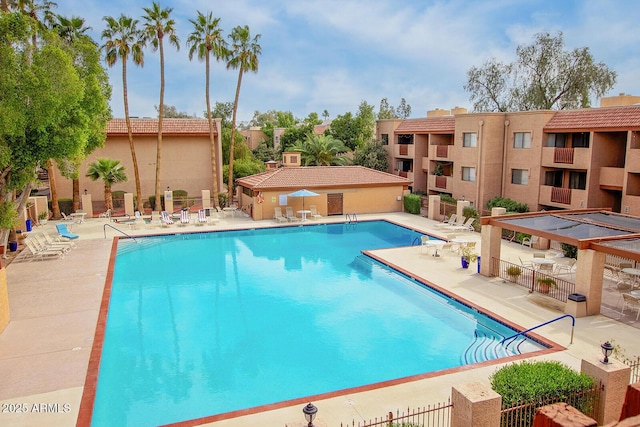 pool with a patio area and fence