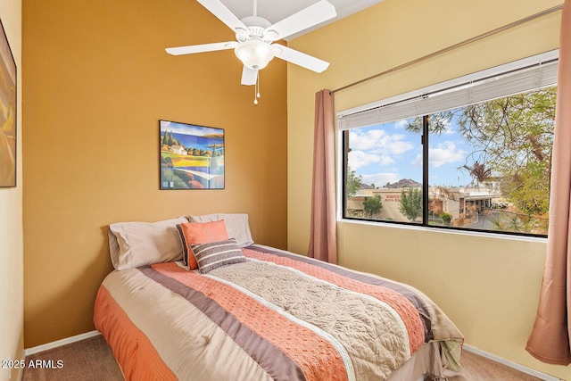 carpeted bedroom featuring baseboards and a ceiling fan