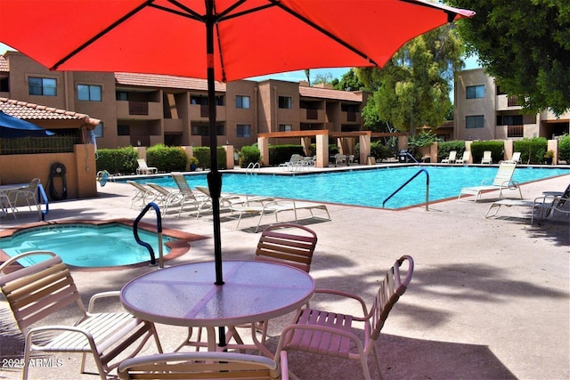 community pool featuring a community hot tub and a patio area