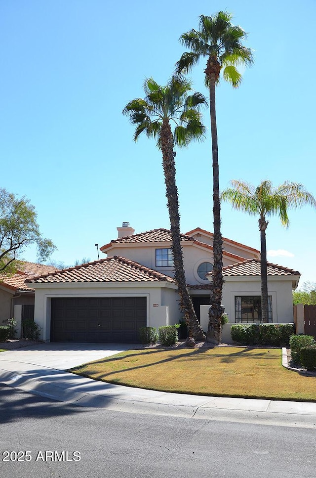 mediterranean / spanish-style house with a garage and a front yard