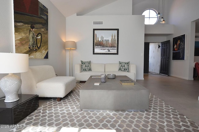 living room featuring concrete flooring and high vaulted ceiling