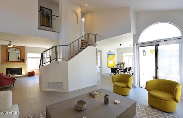 living room with ceiling fan and a high ceiling