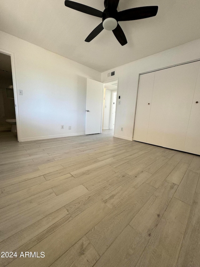 unfurnished bedroom featuring a closet, light hardwood / wood-style floors, and ceiling fan