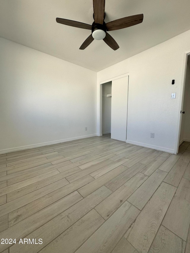 unfurnished bedroom with ceiling fan, light hardwood / wood-style floors, and a closet