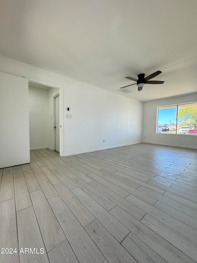 empty room with light hardwood / wood-style floors and ceiling fan