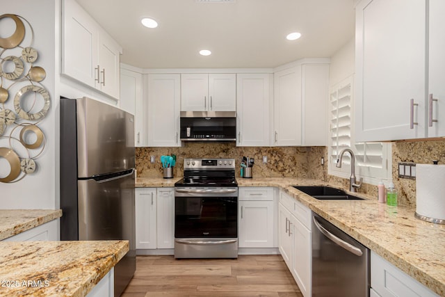 kitchen with white cabinets, appliances with stainless steel finishes, tasteful backsplash, and sink