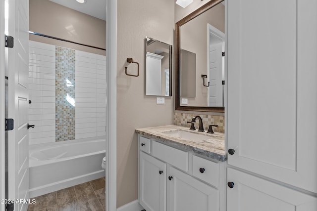 full bathroom with tiled shower / bath combo, backsplash, toilet, vanity, and hardwood / wood-style flooring