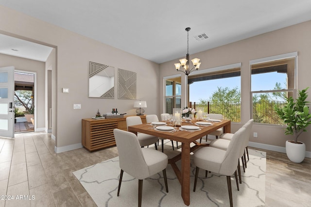 dining space featuring light hardwood / wood-style floors and an inviting chandelier