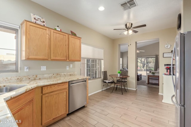 kitchen featuring appliances with stainless steel finishes, ceiling fan, sink, light brown cabinets, and light hardwood / wood-style floors