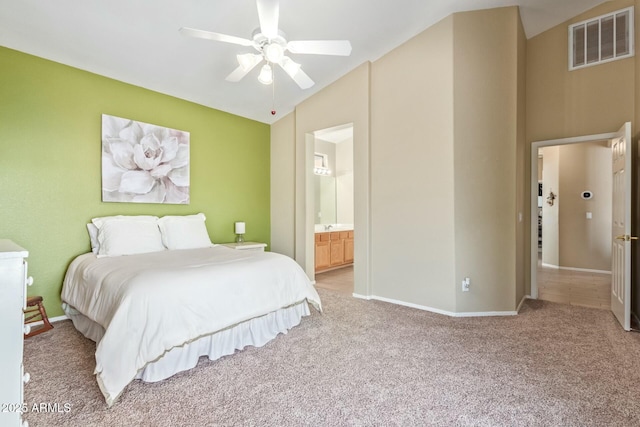 bedroom featuring ceiling fan, lofted ceiling, light carpet, and connected bathroom