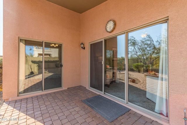 view of exterior entry with a patio