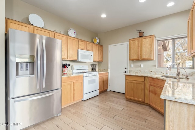 kitchen featuring light stone countertops, white appliances, light hardwood / wood-style flooring, and sink