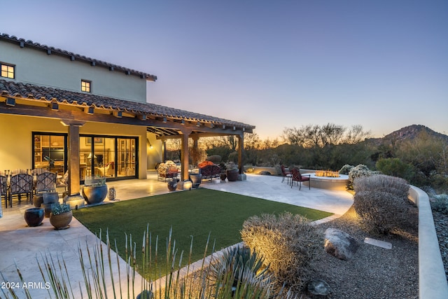 yard at dusk with a pergola, a mountain view, and a patio area