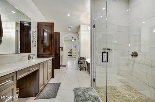 full bathroom with a stall shower, a freestanding tub, tile patterned floors, vanity, and a ceiling fan