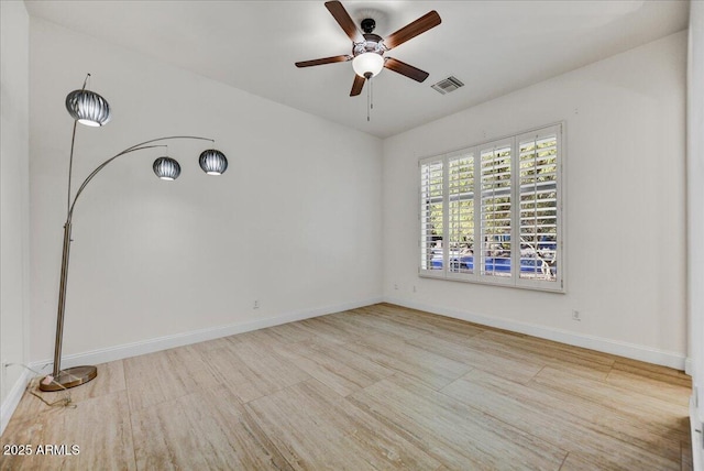 unfurnished room featuring visible vents, a ceiling fan, and baseboards