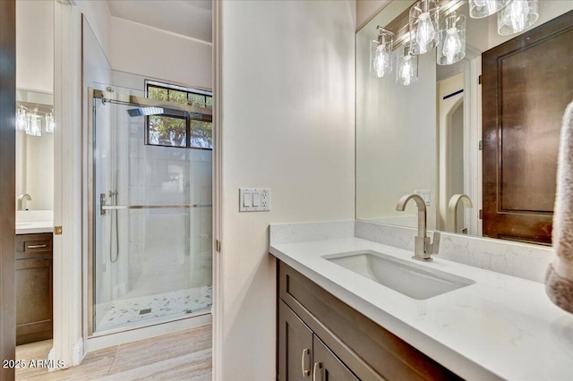 full bathroom with a stall shower, vanity, and wood finished floors