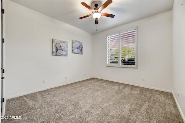 carpeted spare room with baseboards and ceiling fan