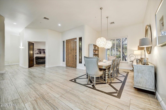 dining area featuring a notable chandelier, baseboards, and visible vents