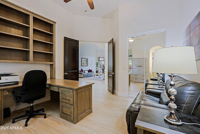 office with a high ceiling, a ceiling fan, and baseboards