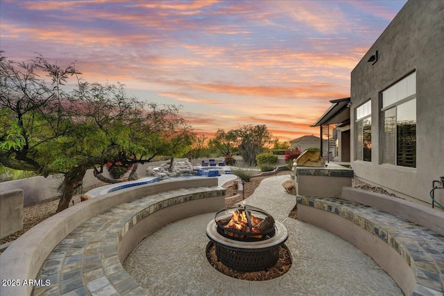 view of patio featuring an outdoor pool and a fire pit