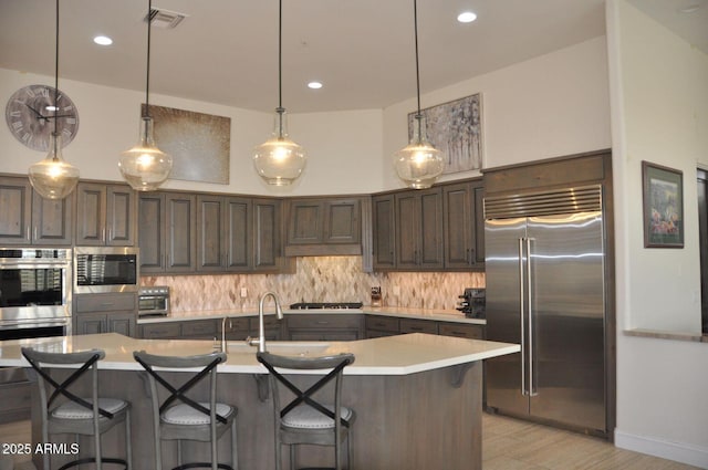 kitchen featuring light countertops, visible vents, tasteful backsplash, and stainless steel appliances