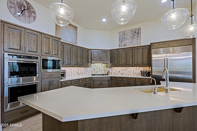 kitchen featuring light countertops, tasteful backsplash, and built in appliances