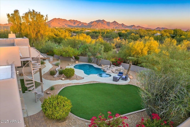 view of pool featuring a fenced in pool, a yard, a fenced backyard, a patio area, and a mountain view