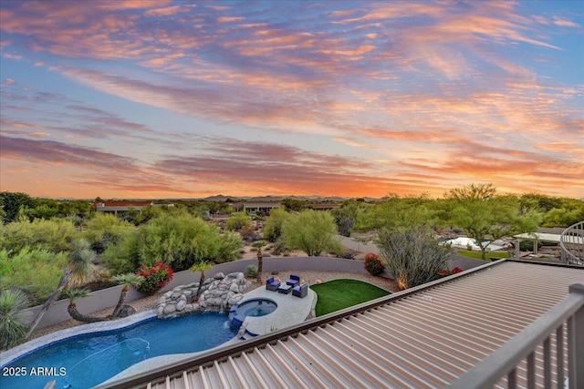 pool at dusk with a fenced in pool, an in ground hot tub, a fenced backyard, and a patio area