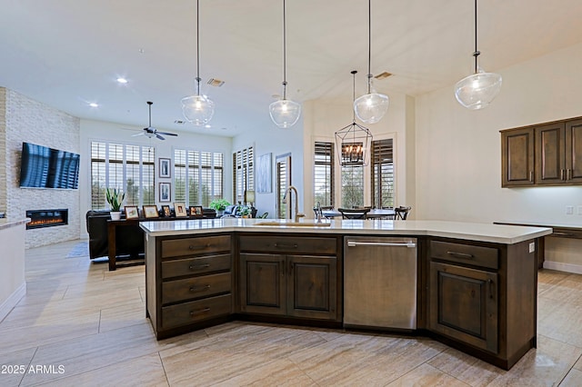 kitchen with dark brown cabinetry, open floor plan, dishwasher, light countertops, and a sink