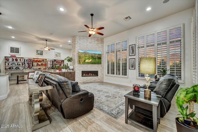 living area with visible vents, recessed lighting, a fireplace, and light wood-type flooring