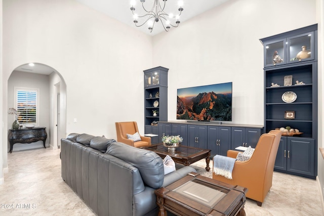 living room with built in shelves, a chandelier, and a high ceiling