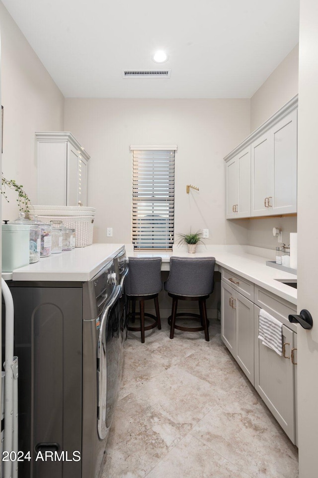 laundry room featuring washing machine and dryer and cabinets