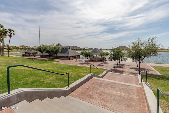 view of home's community with a gazebo, a water view, and a lawn