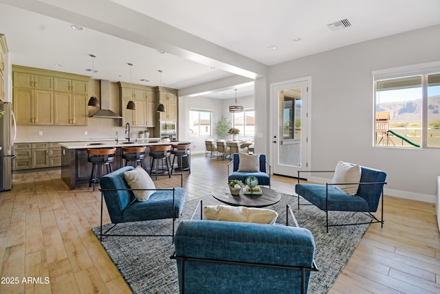 living area featuring recessed lighting, visible vents, light wood-style flooring, and baseboards