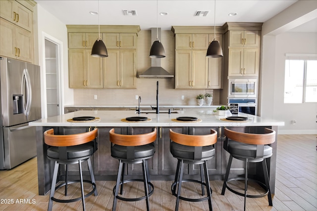 kitchen with wall chimney exhaust hood, appliances with stainless steel finishes, visible vents, and decorative backsplash