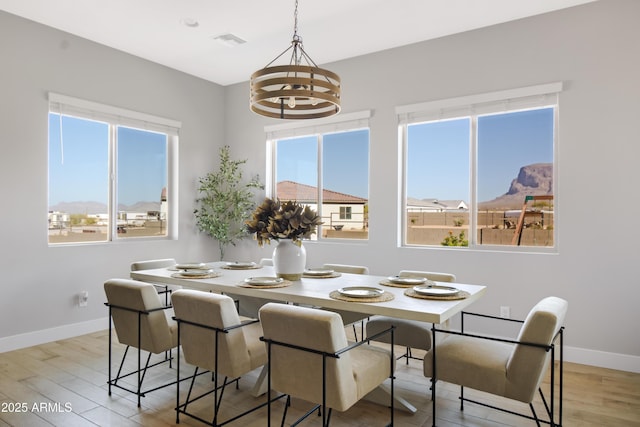 dining room with a chandelier, visible vents, baseboards, and wood finished floors