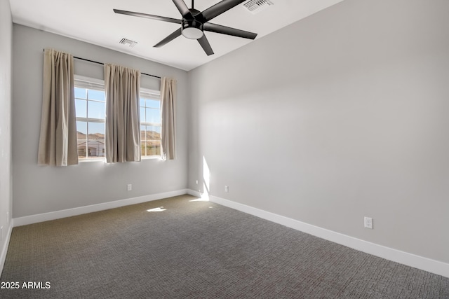 carpeted spare room featuring a ceiling fan, visible vents, and baseboards