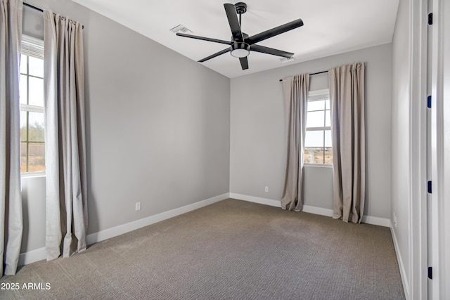 carpeted empty room with visible vents, baseboards, and a ceiling fan