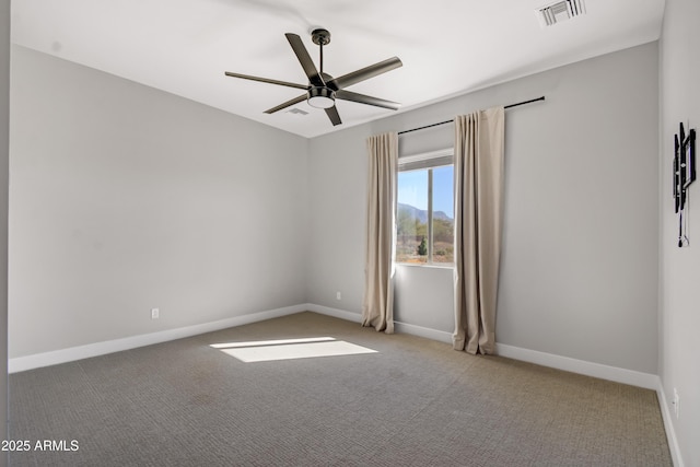 carpeted spare room with a ceiling fan, visible vents, and baseboards