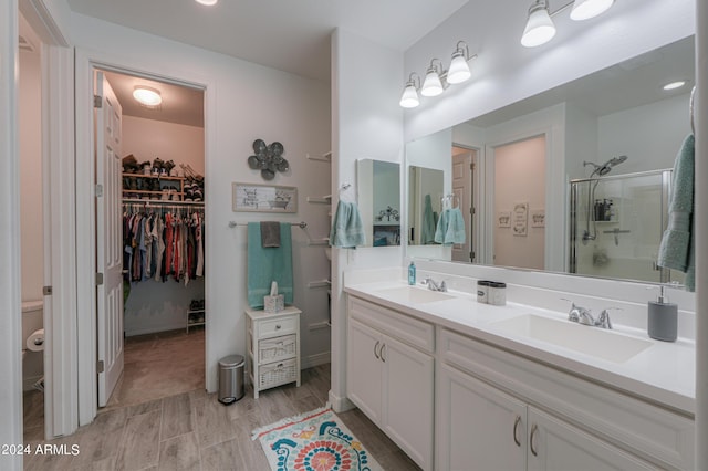 bathroom with a shower with door and vanity