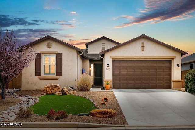 ranch-style house featuring stucco siding, an attached garage, and driveway