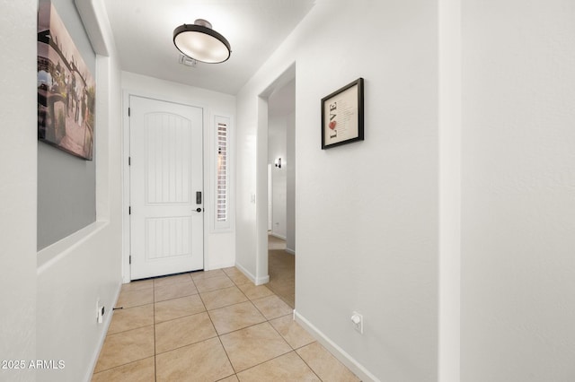 entryway featuring light tile patterned flooring and baseboards
