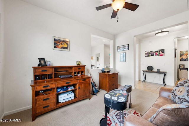 living room featuring light tile patterned floors, baseboards, light colored carpet, and ceiling fan