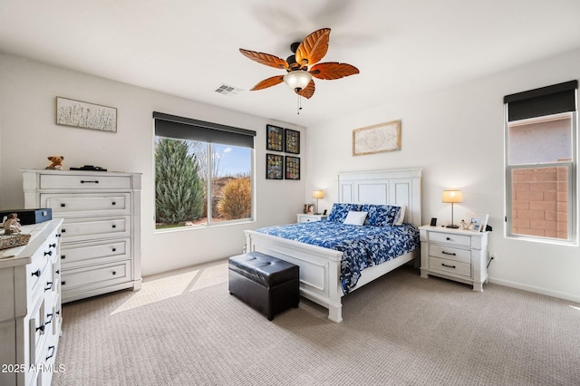 bedroom featuring visible vents, a ceiling fan, and light colored carpet