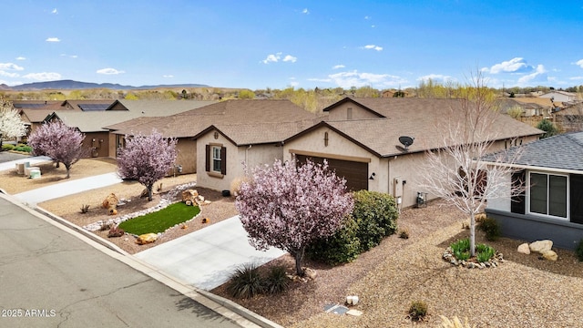 ranch-style house featuring stucco siding, driveway, a garage, and roof with shingles