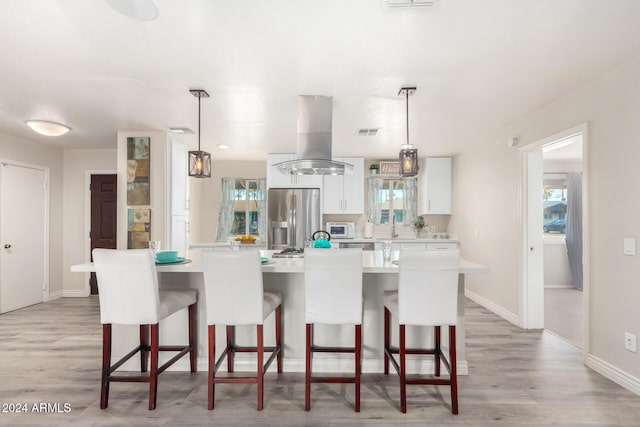 kitchen featuring island exhaust hood, stainless steel refrigerator with ice dispenser, a kitchen island, and pendant lighting