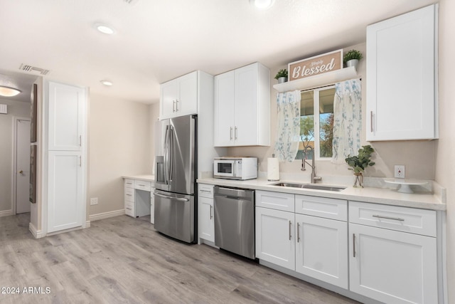 kitchen featuring white cabinets, sink, light wood-type flooring, and stainless steel appliances