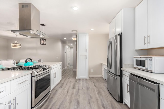 kitchen featuring appliances with stainless steel finishes, light wood-type flooring, island range hood, decorative light fixtures, and white cabinetry