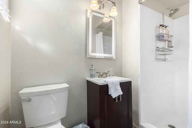 bathroom featuring a shower with curtain, vanity, and toilet