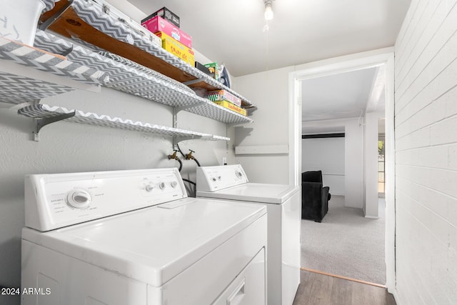 washroom featuring hardwood / wood-style flooring and washer and clothes dryer